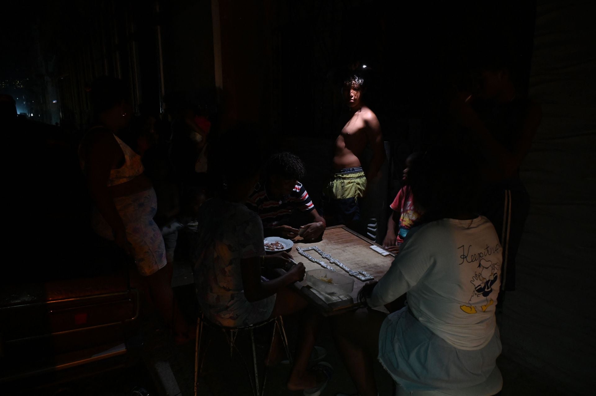 Un grupo de cubanos juega al dominó en la oscuridad en una calle durante un apagón nacional causado por un fallo en la red eléctrica en La Habana.