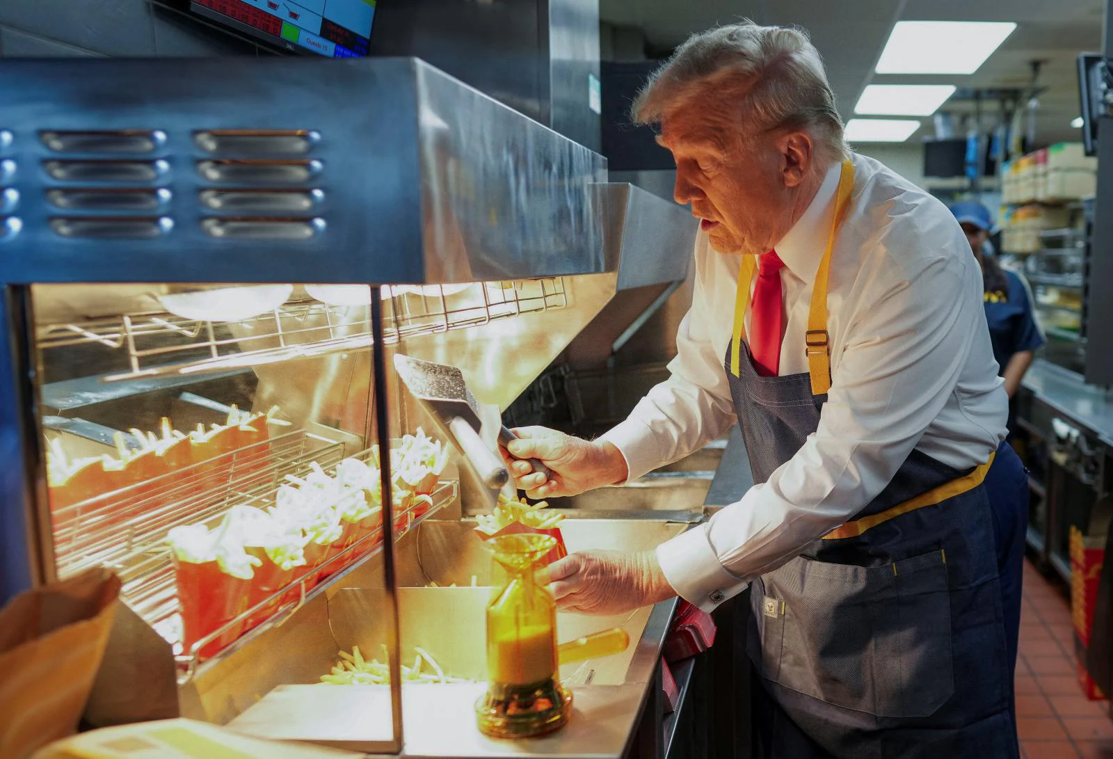 El candidato presidencial republicano y expresidente de Estados Unidos, Donald Trump, friendo patatas fritas en un McDonald's