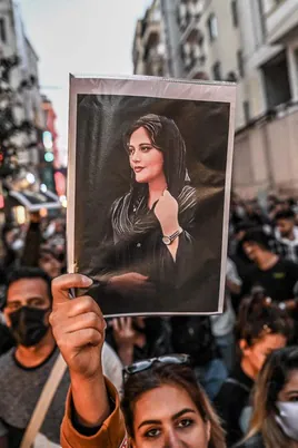 Un manifestante sostiene un retrato de Mahsa Amini durante una protesta en apoyo de la joven iraní en Estambul