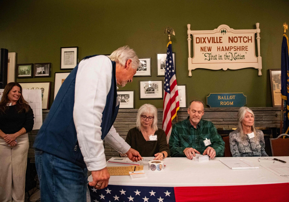 Un residente de Dixville Notch muestra su identificación mientras se registra para emitir su voto en las elecciones estadounidenses en Dixville Notch.