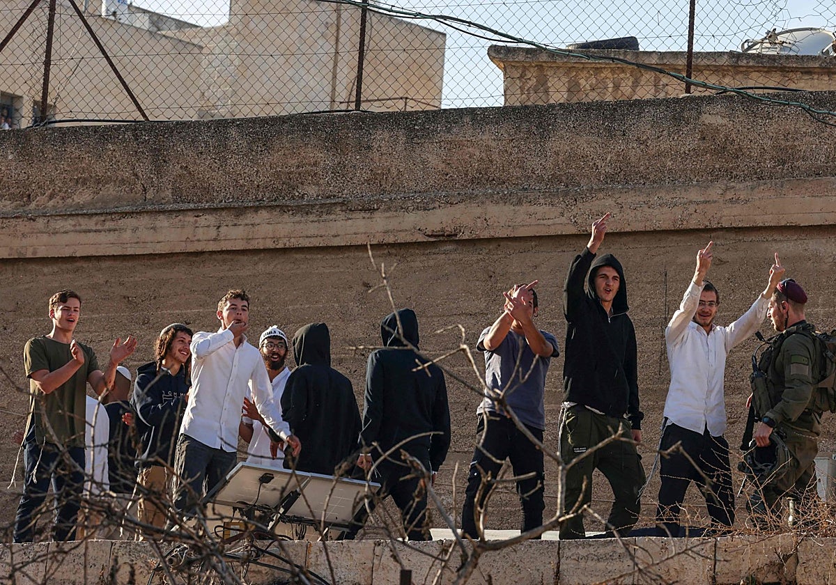 Los colonos israelíes muestran el dedo medio desde los tejados mientras se burlan de los palestinos que pasan por allí,