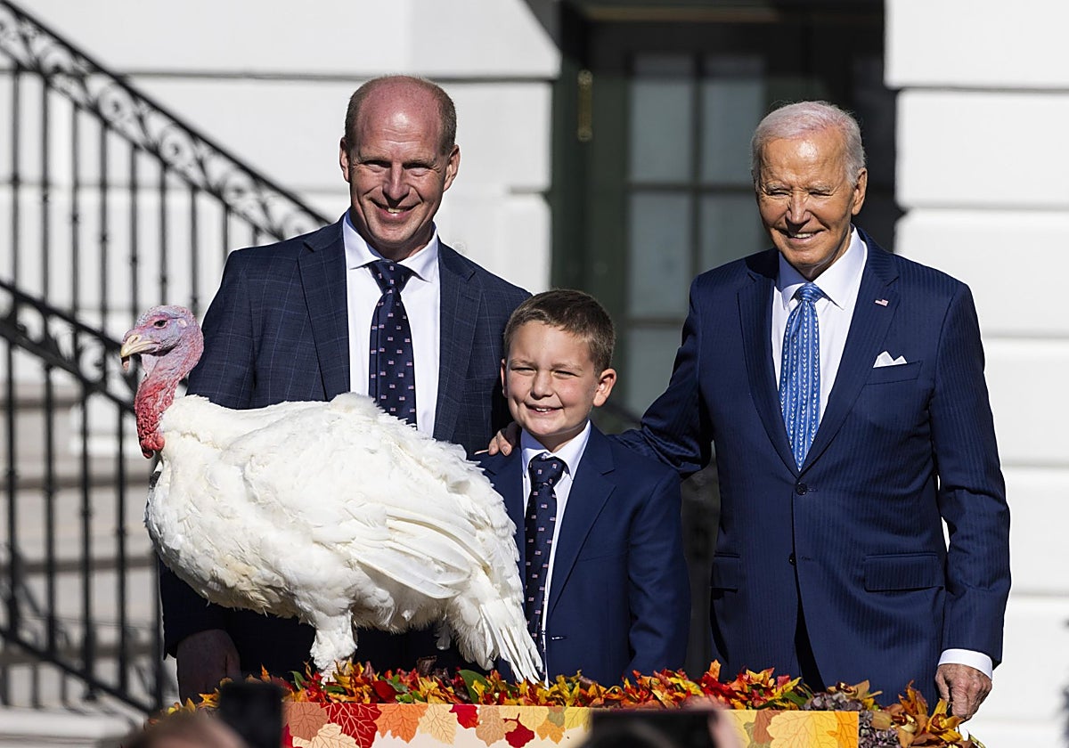 El presidente de Estados Unidos, Joe Biden (d), posa con Peach (izq. al frente), uno de los dos pavos del Día de Acción de Gracias que indultó