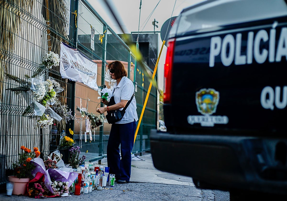 : Activistas depositan flores en el altar del bar Los Cantaritos durante una marcha por la paz en Querétaro .