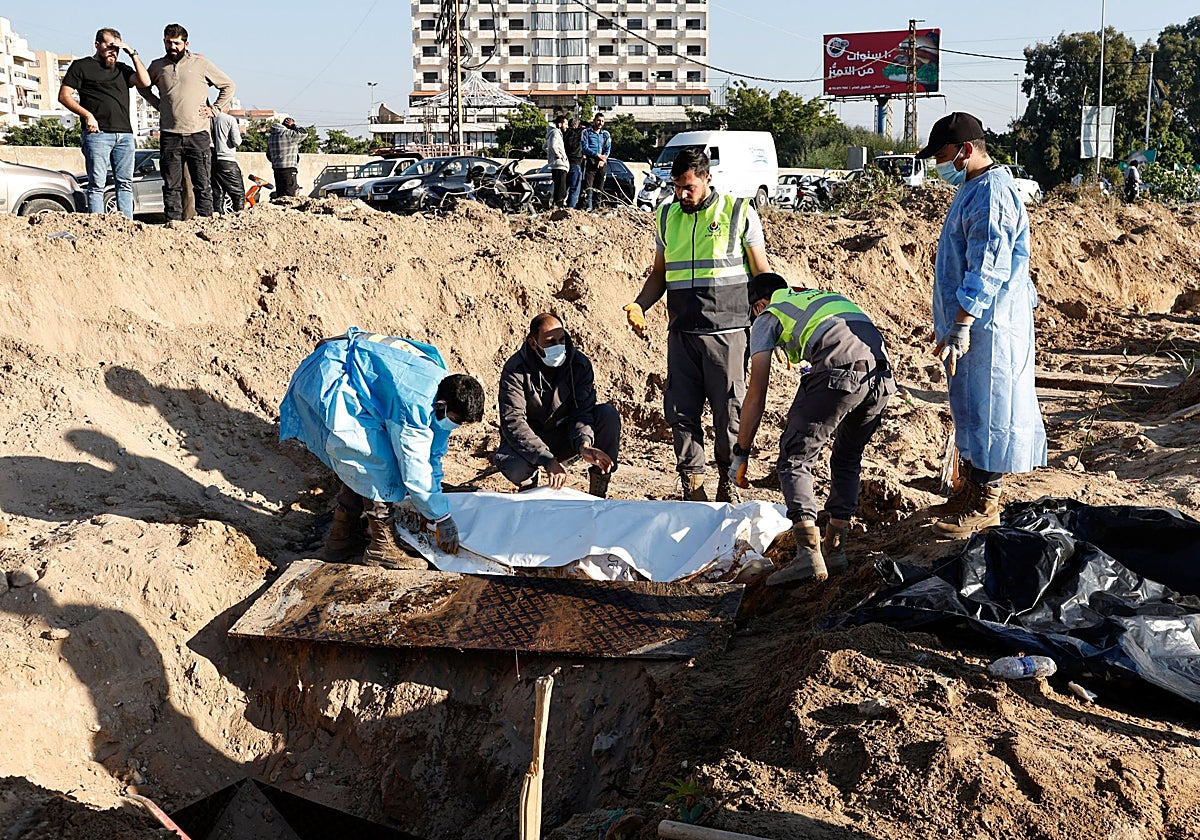 Miembros de Defensa Civil retiran los cuerpos de las personas fallecidas durante las hostilidades entre Israel y Hizbolá para llevarlos a sus pueblos, después de un alto el fuego entre los dos, en Tiro