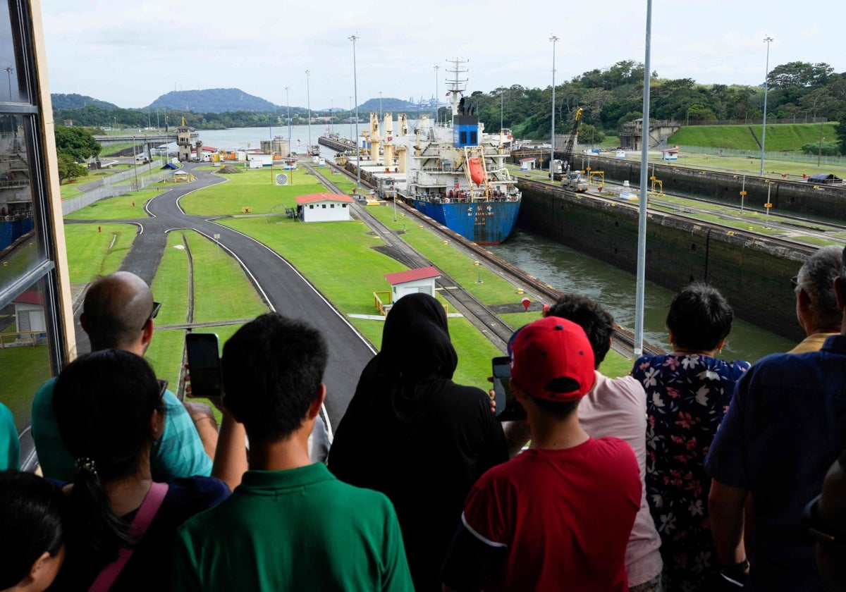 Los turistas observan el tránsito de un barco de carga por el Canal de Panamá en la ciudad de Panamá el 23 de diciembre de 2024.