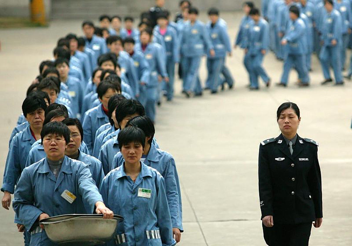 Los presos caminan junto a una escolta policial en la prisión de Nanjing, en el este de China