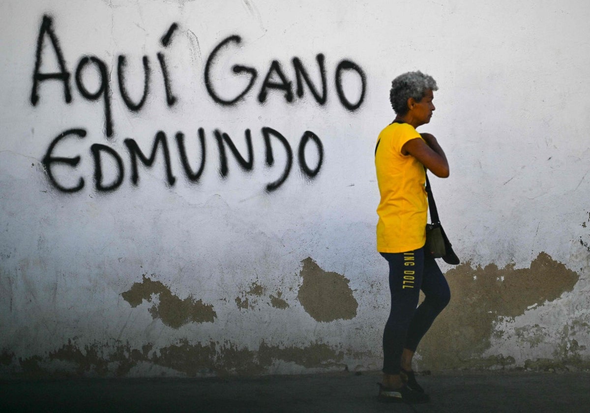 Una mujer camina frente a un grafiti que dice «Aquí ganó Edmundo», en Caracas , el 8 de enero de 2025.