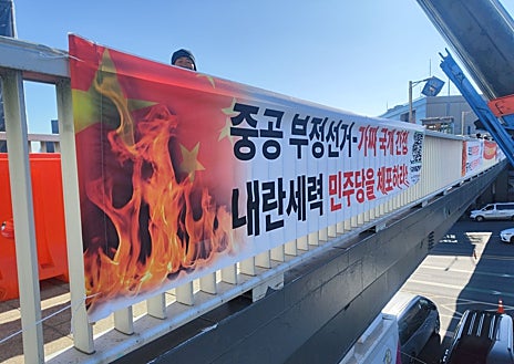 Imagen secundaria 1 - Una partidaria de Yoon con el cartel 'Stop the steal', una pancarta que carga contra China y un policía que controla el acceso a las manifestaciones