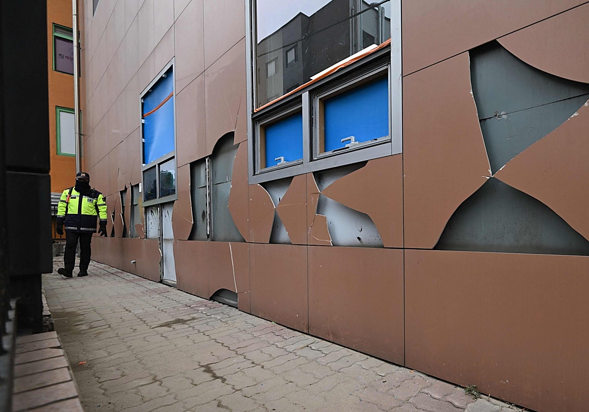 Un policía hace guardia junto a la dañada pared del Tribunal del Distrito Oeste de Seúl tras los disturbios