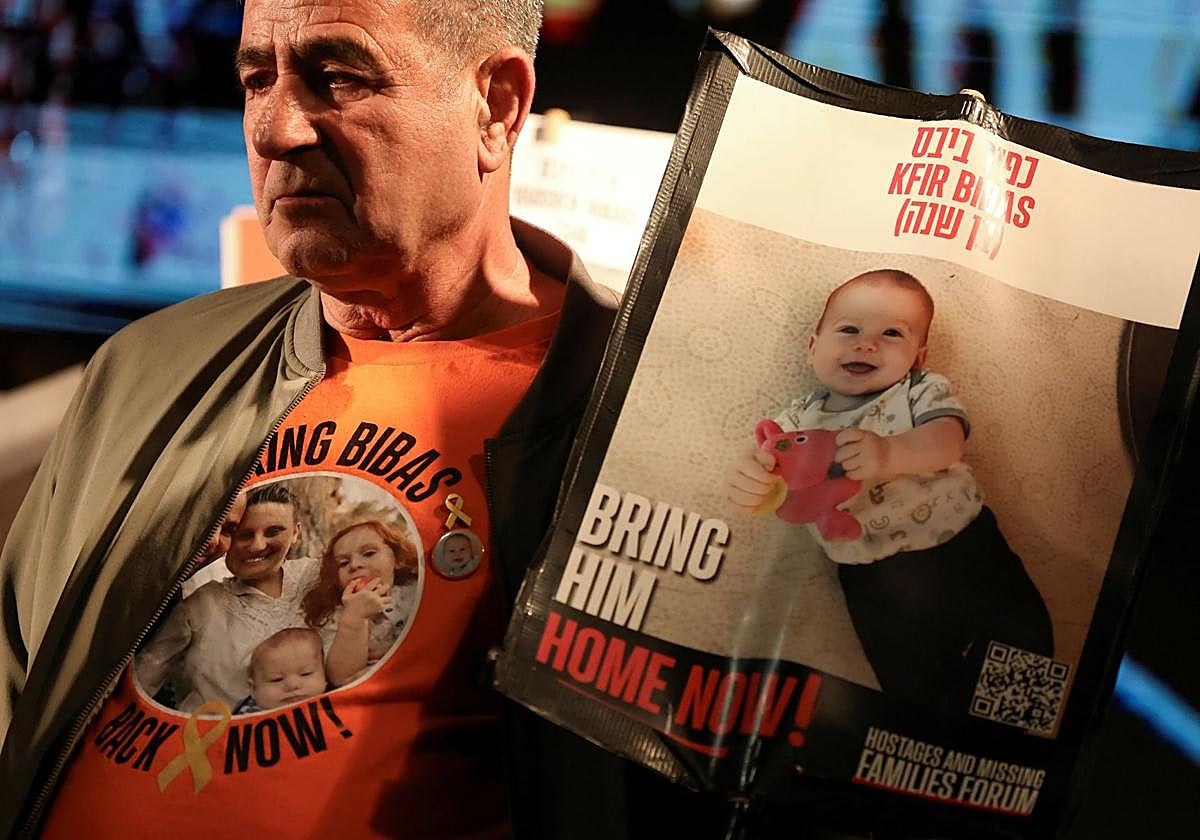 Eli Bibas, abuelo del rehén más joven en Gaza, sostiene su foto esperando la llegada de la tregua