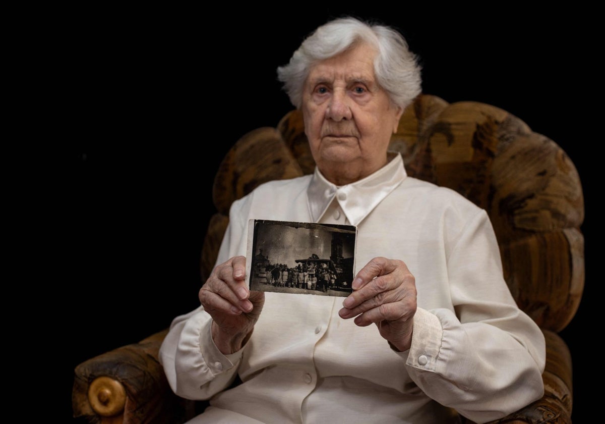 La sobreviviente del Holocausto, Janina Iwanska, de 94 años, sostiene una fotografía de ella y un grupo de otras niñas regresando a casa después de la Segunda Guerra Mundial