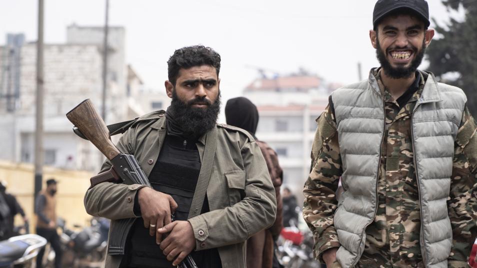 Dos hombres armados pasean por las calles de Idlib
