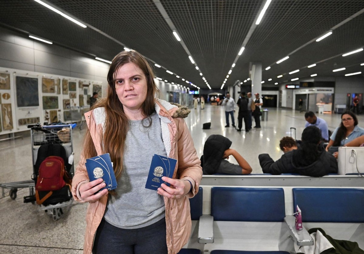 Giluania Sena, una migrante brasileña deportada de Estados Unidos, muestra su pasaporte en el aeropuerto Confins en Belo Horizonte