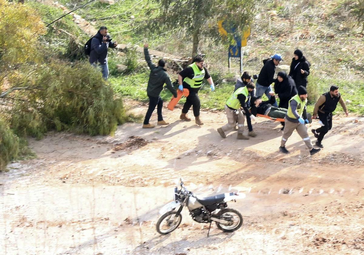 Rescatistas llevan a una persona herida a tiros por soldados israelíes que se dirigía al sur del Líbano