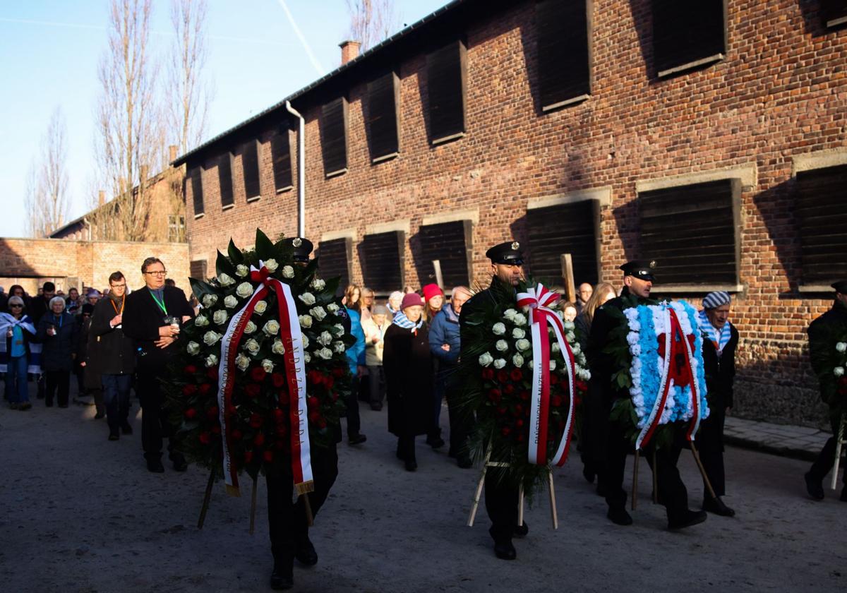 Soldados y supervivientes realizan la ofrenda floral a las víctimas del campo de concentración de Auschwitz-Birknenau