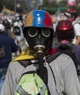 Imagen secundaria 2 - Algunos manifestantes asistían a las protestas con cascos, chalecos antibalas, máscaras antigás y gruesos guantes de jardinería para no quemarse al devolver los cartuchos de gases lacrimógenos