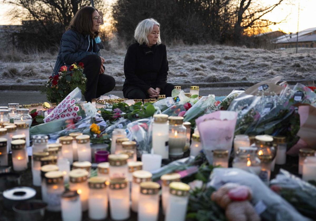 Varias personas encienden velas en una vigilia improvisada cerca del centro de educación para adultos Campus Risbergska en Orebro, Suecia