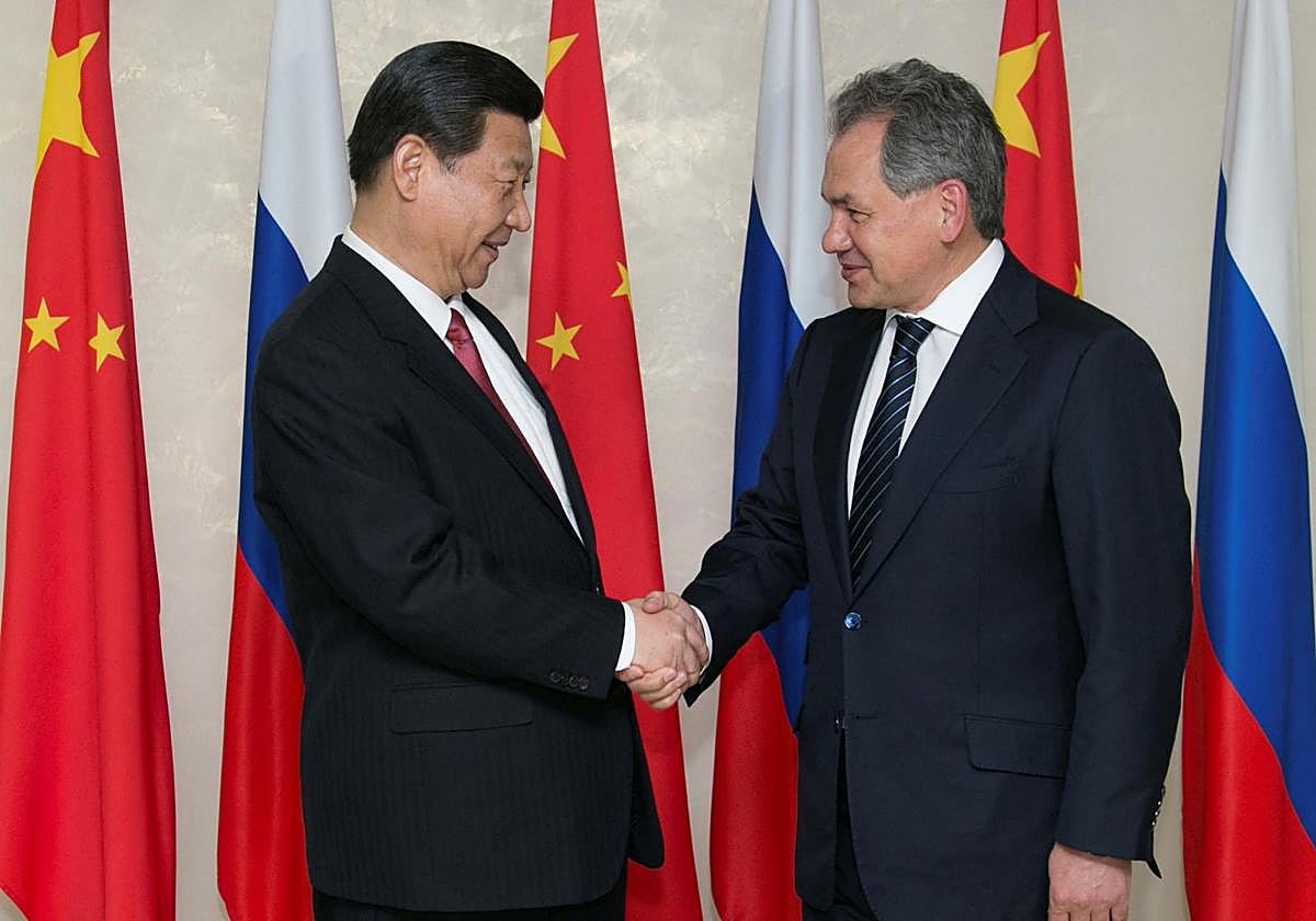 El secretario del Consejo de Seguridad ruso, Sergei Shoigu (d), estrecha la mano del presidente chino, Xi Jinping (i), durante su reunión en Moscú en una imagen de archivo