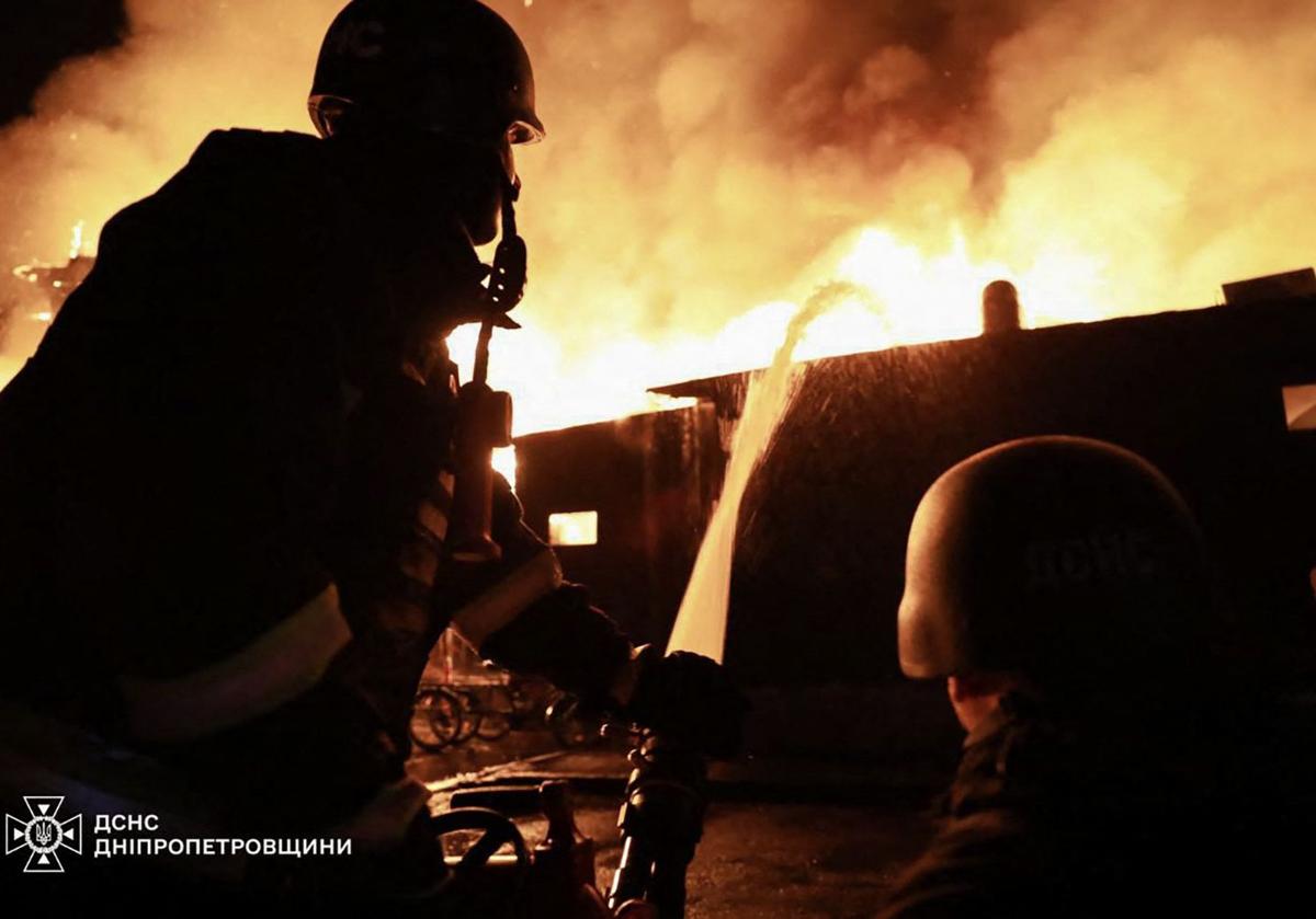 Bomberos ucranianos tratan de sofocar el fuego tras un ataque ruso con drones en Dnipro