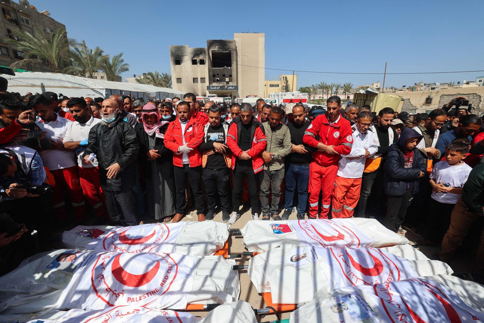 Sanitarios de la Media Luna Roja Palestina rezan por los cuerpos de los compañeros encontrados