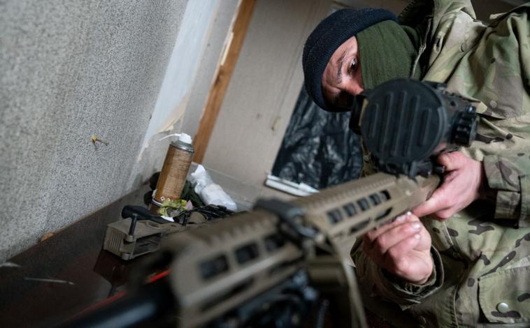 Imagen principal - Snijok limpia un fusil en la base de los francotiradores (arriba). Debajo, un soldado de la unidad de francotiradores yendo al lugar del ensayo y la foto de un corte sagital del TAC craneal de Maliuk después de recibir un disparo en la cabeza