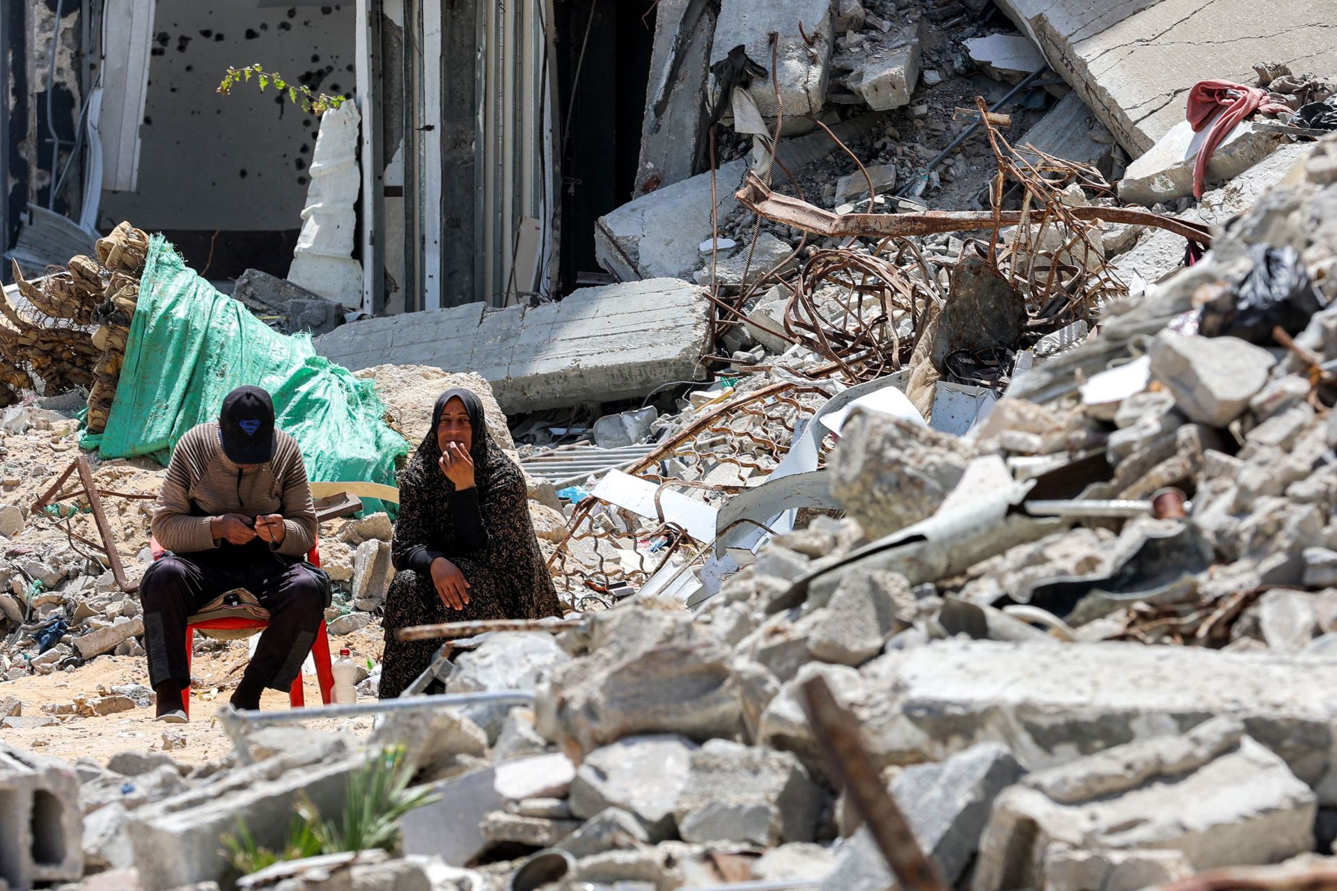 Palestinos se reúnen entre las ruinas de un ataque israelí en Gaza