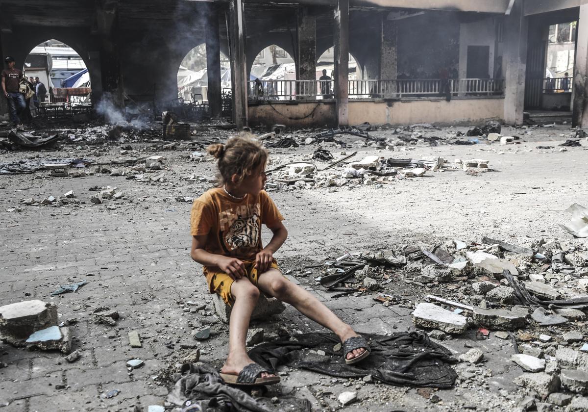Una niña atestigua la destrucción tras un bombradeo en una escuela en ciudad de Gaza, este miércoles