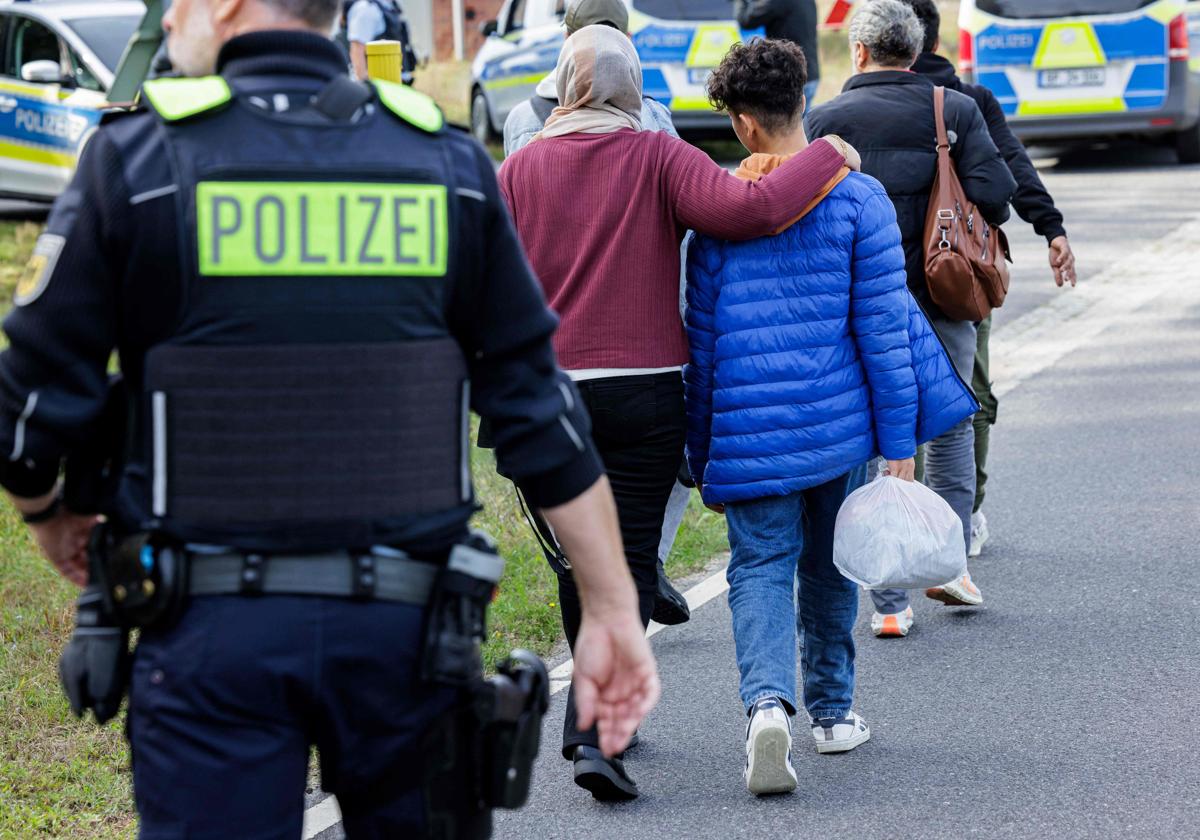 Un oficial de policía acompaña a un grupo de inmigrantes en la frontera alemana, en una imagen de archivo