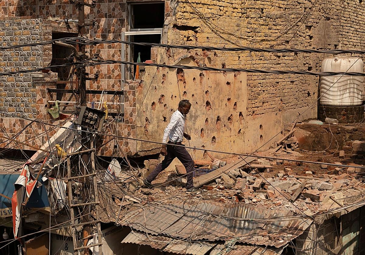 Un hombre camina entre los escombros en el techo de una casa dañada, luego de la operación militar de Pakistán contra India , en Rehari, Jammu