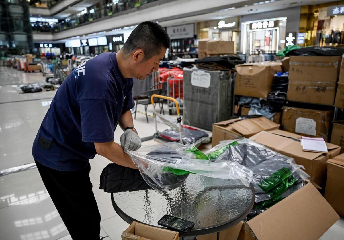 Un hombre empaqueta ropa en Puyuan Sweater City, un mercado que vende principalmente artículos de punto, en Tongxiang, en la provincia oriental china de Zhejiang