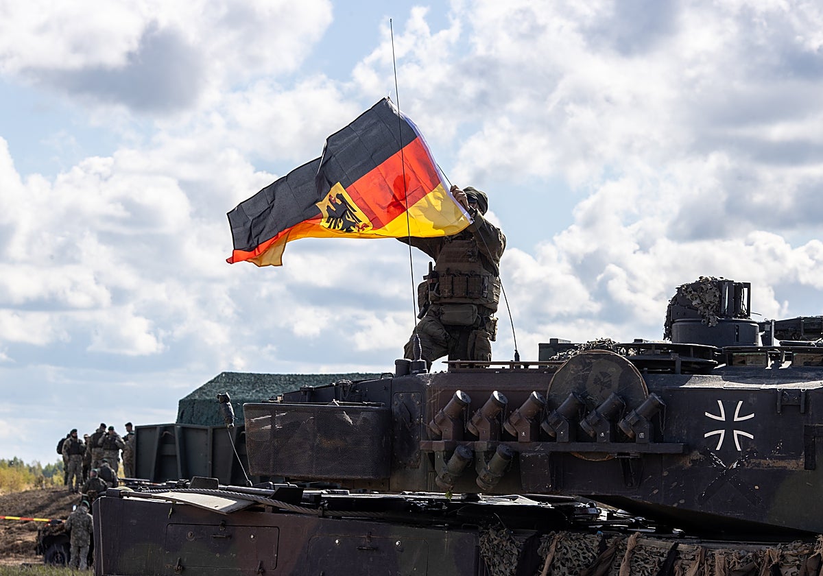 Un soldado alemán coloca la bandera alemana en un tanque Leopard en Gaizuinai frontera de Rusia y Lituania