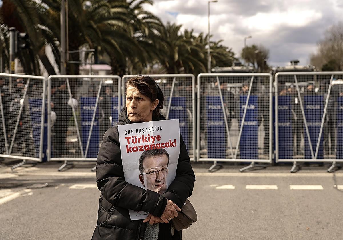 Un seguidor de Ekrem Imamoglu se posiciona delante una barrera policial.