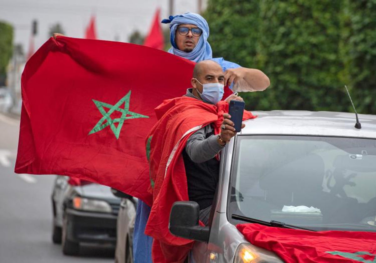 Los marroquíes celebran frente al edificio del parlamento en Rabat el 13 de diciembre de 2020, después de que Estados Unidos adoptara un nuevo mapa oficial de Marruecos que incluye el territorio disputado del Sáhara Occidental.