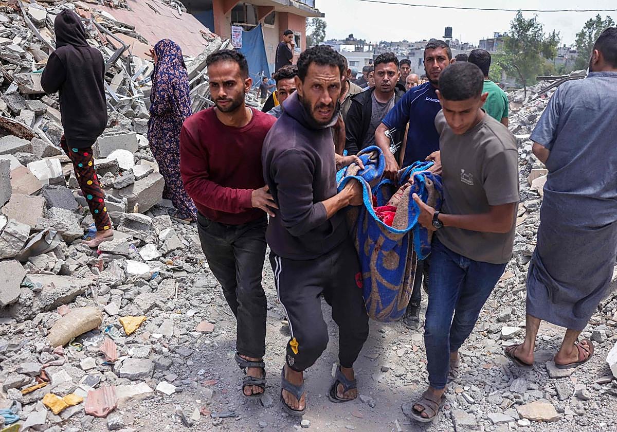 Un grupo de palestinos traslada el cuerpo de una víctima de los ataques en Gaza