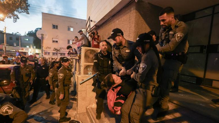 Agentes de policía cargan a una persona mientras familias de rehenes y simpatizantes piden la liberación de todos los rehenes en una manifestación tras los 600 días de guerra