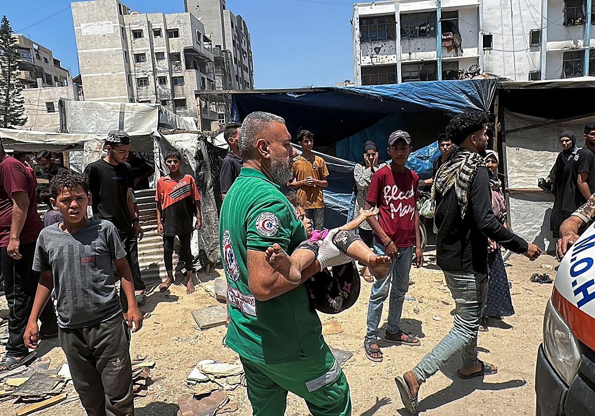 Un hombre huye con su hija tras un bombardeo en Gaza.