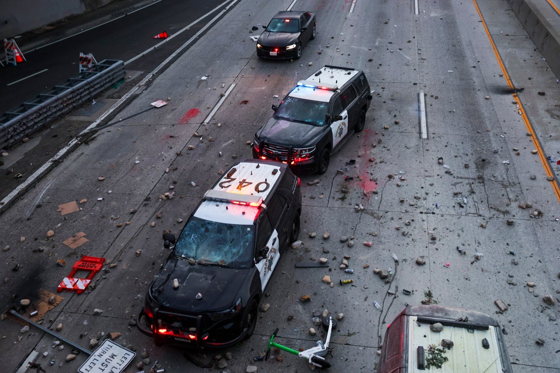 Varios coches de policía, tras ser atacados.