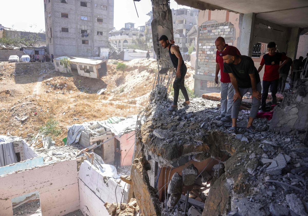 Varias personas inspeccionan el resultado de un bombardeo en Gaza en una imagen de archivo