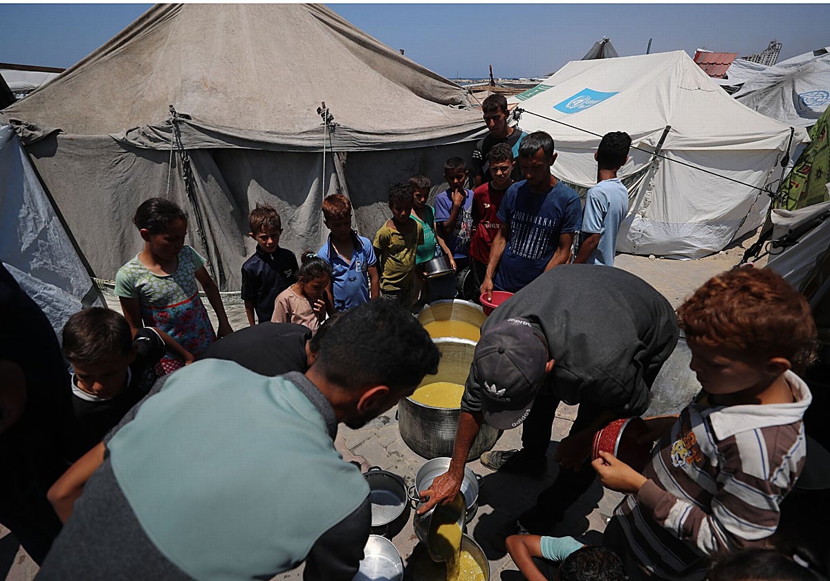 Los palestinos esperan comida en un punto de distribución en la ciudad de Gaza