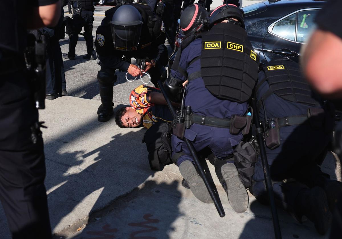 Un manifestante es detenido durante las manifestaciones contra las redadas en Los Ángeles