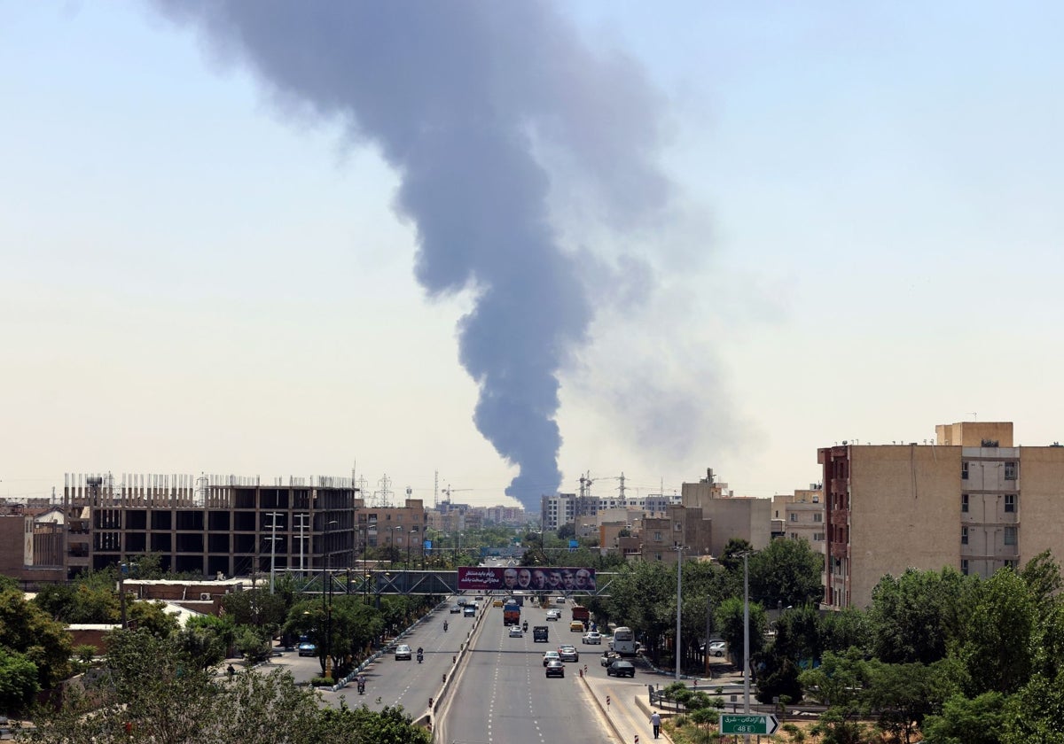 El humo de una refinería de petróleo se eleva sobre edificios residenciales en el sur de Teherán