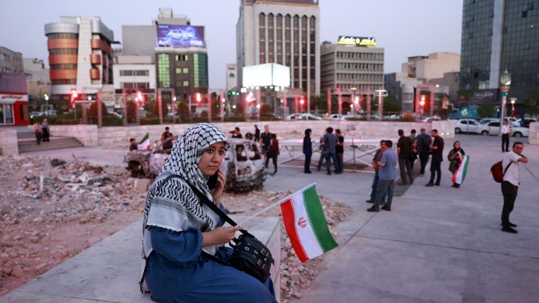 - Una mujer iraní con una bandera nacional escucha a una banda de música tradicional que toca en solidaridad con el pueblo iraní en la plaza Hafte-Tir, en el centro de Teherán