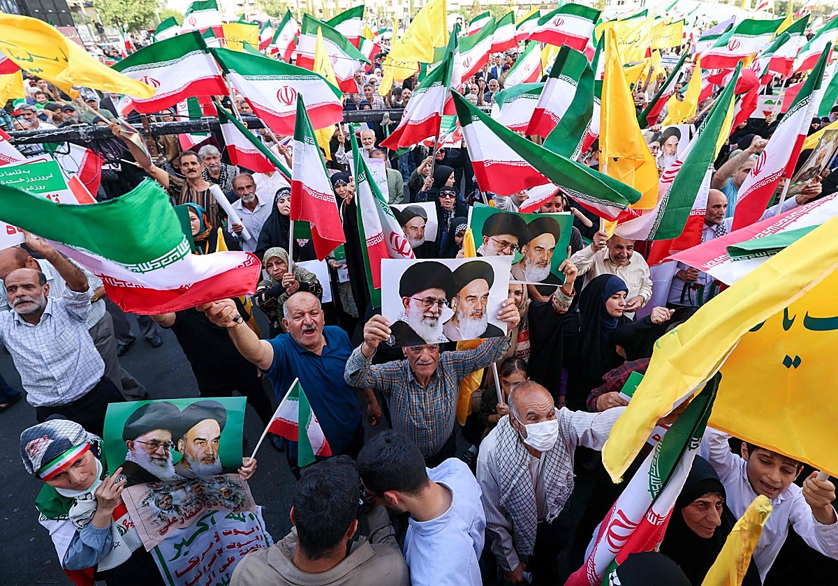Iraníes corean consignas, ondean banderas nacionales y sostienen retratos del líder supremo iraní, el ayatolá Alí Jamenei
