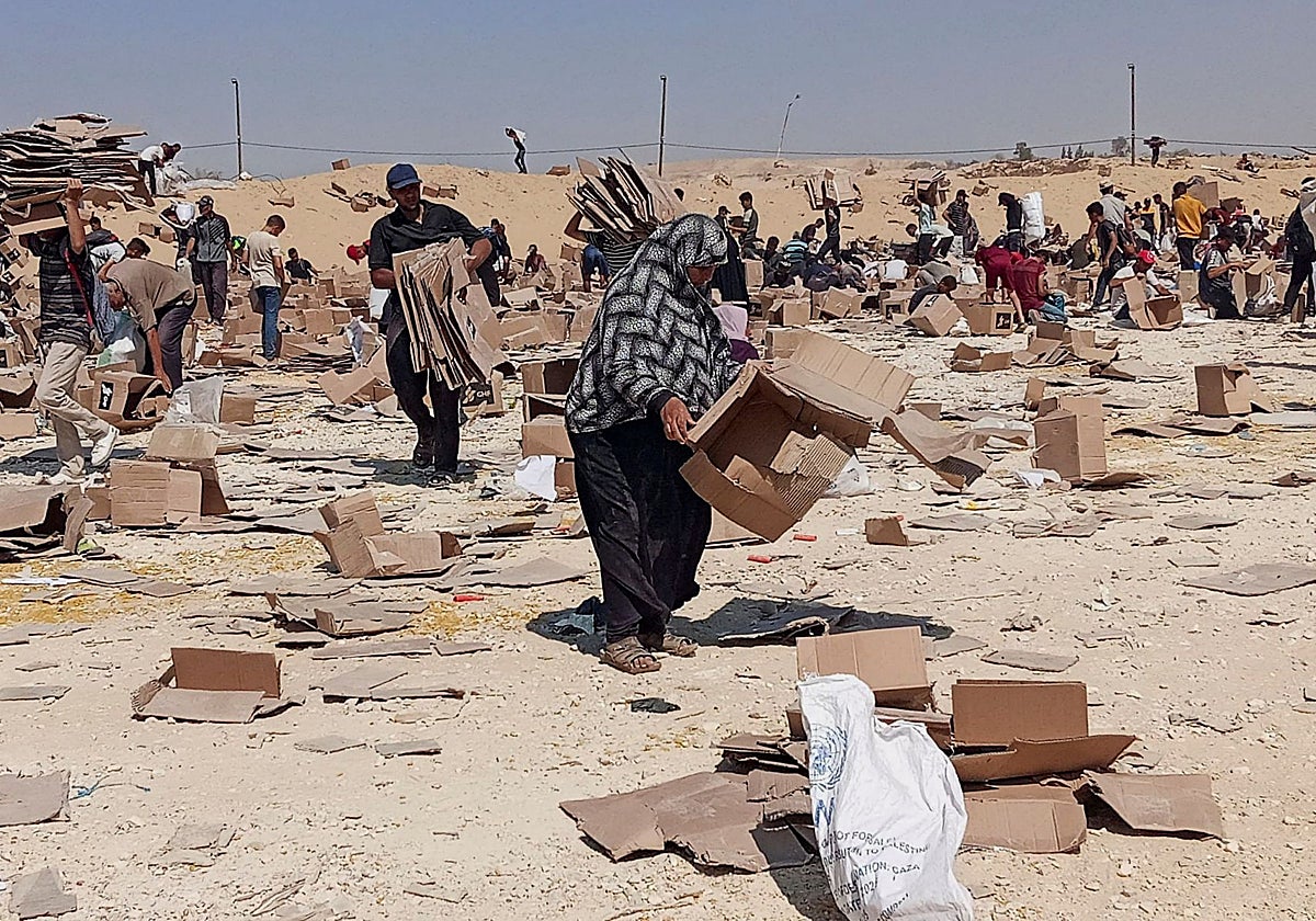 Palestinos se reúnen para recoger lo que queda de suministros del centro de distribución de la Fundación Humanitaria de Gaza respaldada por Estados Unidos, en Rafah