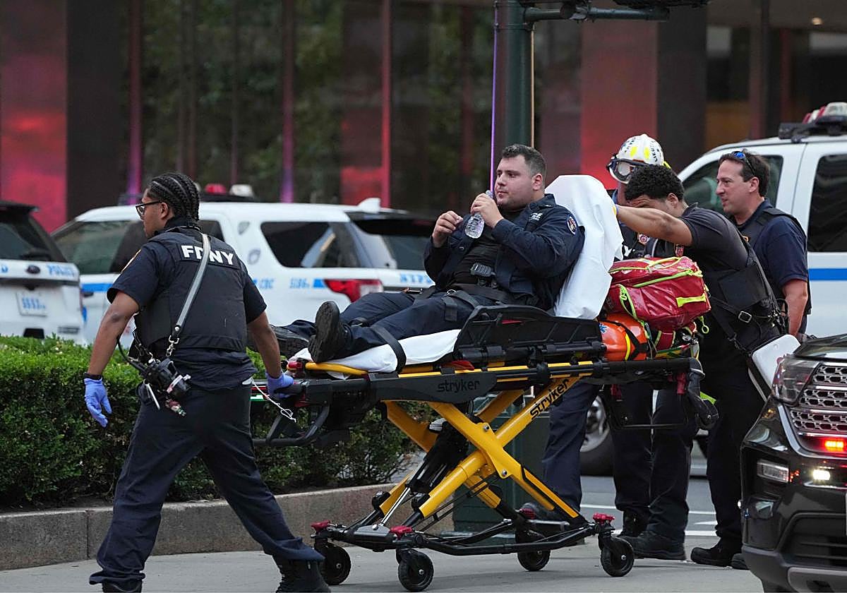 Un policía es trasladado en camilla tras resultar herido en el tiroteo