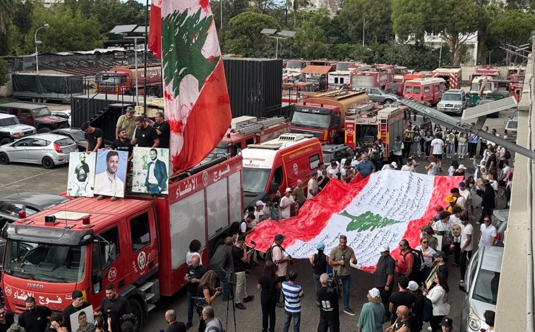Imagen principal - Los bomberos de Beirut, que perdieron a diez compañeros en la explosión, desfilaron ayer junto a las familias de las víctimas (imagen superior horizontal). Al acto acudieron el ministro de Cultura y la responsable de Asuntos Sociales (imagen de arriba horizontal). El doctor Adem, que perdió a su hija Krystel, se unió a la marcha junto a Mireille Khouri, cuyo hijo Elías, de 15 años, murió aquel trágico 4 de agosto de 2020 (imagen de arriba vertical)