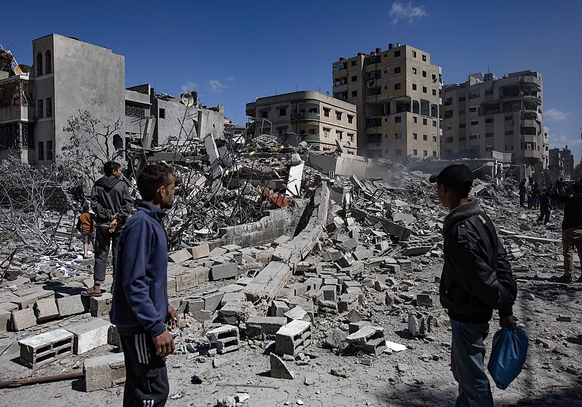 Palestinos inspeccionan una casa destruida en Gaza tras un ataque aéreo de las fuerzas israelíes