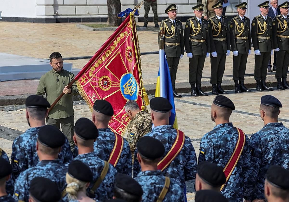 El presidente de Ucrania, Volodímir Zelenski entrega una bandera a un militar durante una ceremonia de celebración del Día de la Independencia de Ucrania, en medio de la invasión rusa