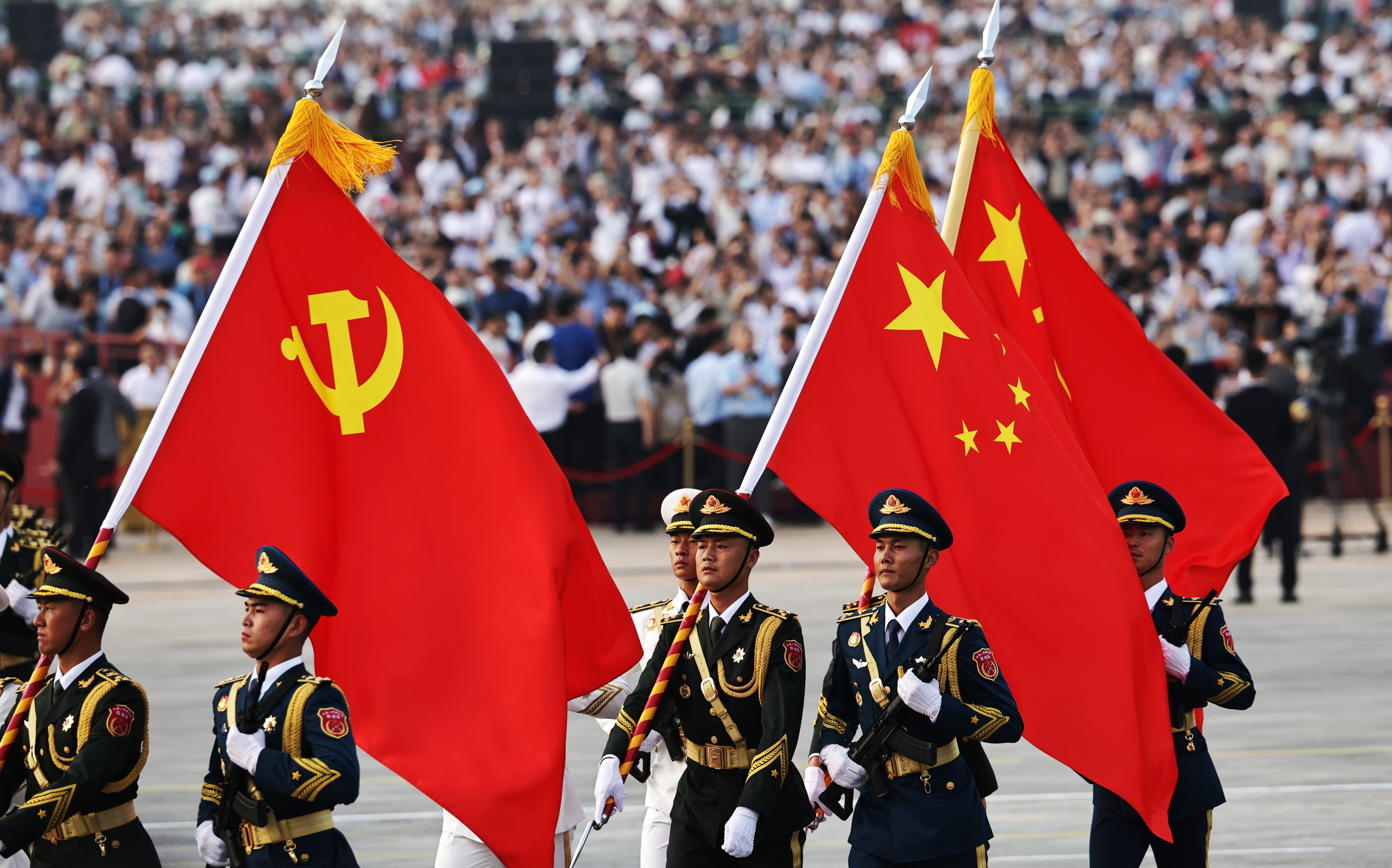 Militares chinos ondean la bandera de su país y la del Partido Comunista de China