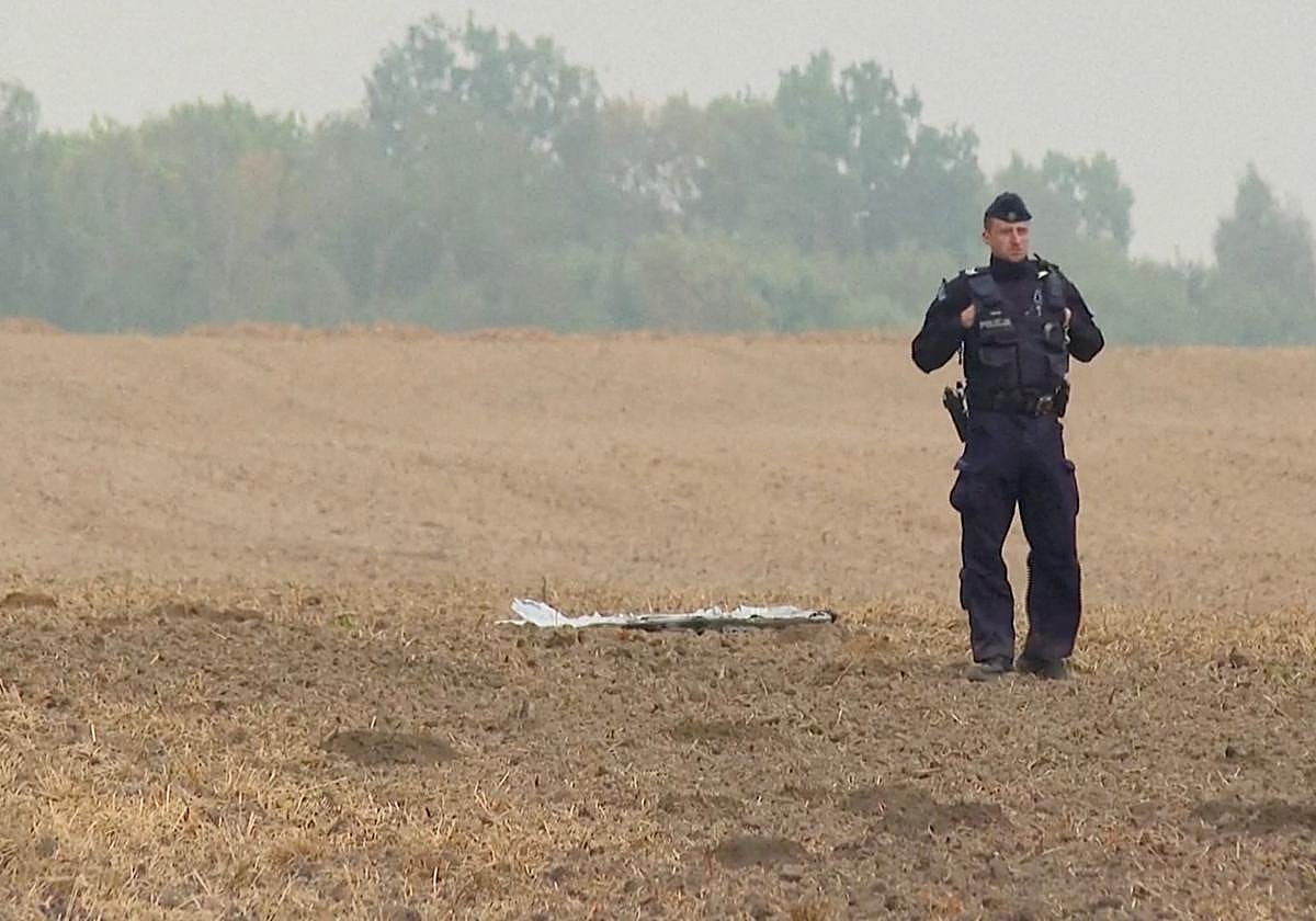 Un policía polaco junto a un fragmento de un vehículo aéreo no tripulado (UAV), después de que drones rusos violaran el espacio aéreo polaco